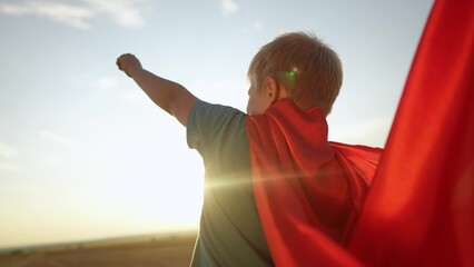 kid superhero. boy happy family a dream concept. baby boy superhero close-up in red cape at sunset. portrait child superhero close-up from the back. strength lifestyle fantasy concept - 767792524