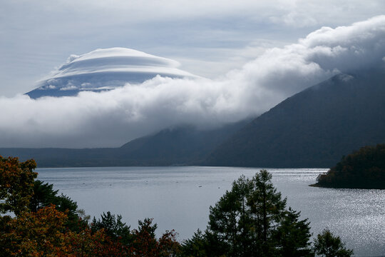 山梨県・本栖湖ごしに眺める傘雲に隠れた富士山