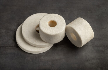 Abrasive wheels for processing and grinding metal products, close-up on a dark background.