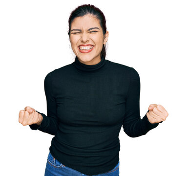 Young hispanic woman wearing casual clothes very happy and excited doing winner gesture with arms raised, smiling and screaming for success. celebration concept.