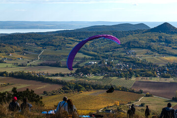 Paragliding on the mountainside, a lake in the distance.