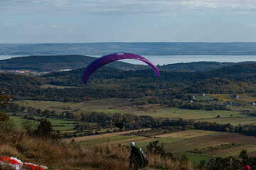Paragliding on the mountainside, a lake in the distance.