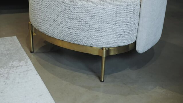 Close-up. A chair with golden legs on a concrete light floor