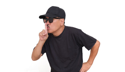 Guy wearing black, putting his finger on his lips to tell people to be quiet