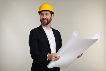 Architect in hard hat with draft on gray background