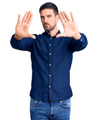 Young handsome man wearing casual shirt doing frame using hands palms and fingers, camera perspective