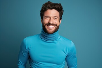 A man in a blue sweater is smiling and looking at the camera