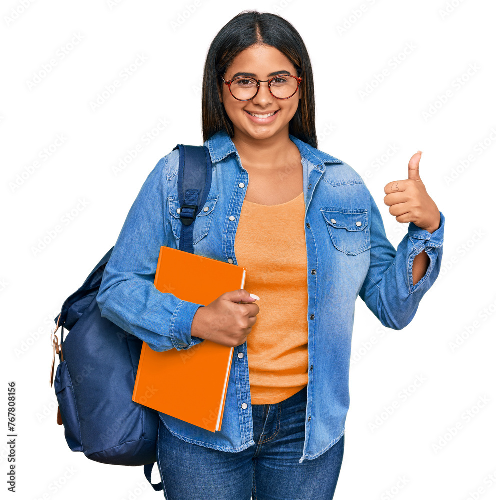 Sticker Young latin girl wearing student backpack and holding books doing happy thumbs up gesture with hand. approving expression looking at the camera showing success.