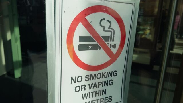 No smoking or vaping sign on a display window in city