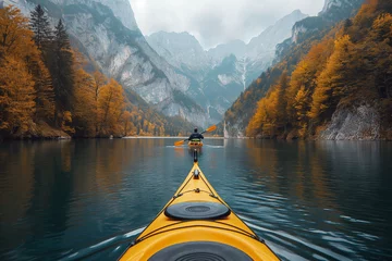 Foto op Canvas back of male kayaker kayaking on a lake with a landscape of mountain peaks and forests in nature in autumn © alexkoral