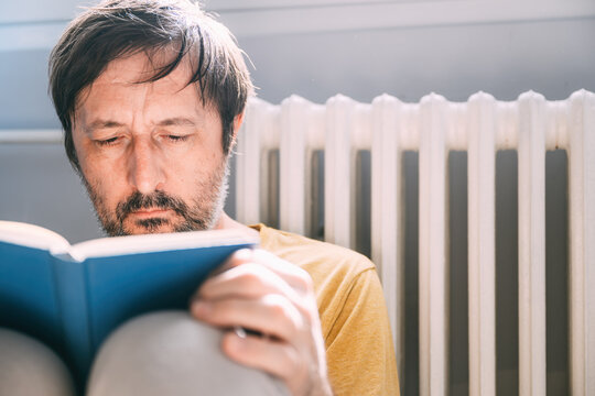 Passionate reader enjoying the book while sitting alone at home in summer morning