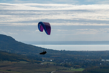 Paragliding on the mountainside, a lake in the distance.