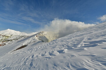Fototapeta na wymiar Smoke rising from winter landscape snow-capped Mt. Tokachi volcano, Hokkaido, Japan