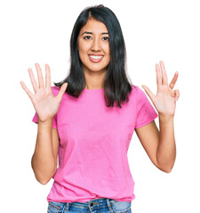 Beautiful asian young woman wearing casual pink t shirt showing and pointing up with fingers number nine while smiling confident and happy.