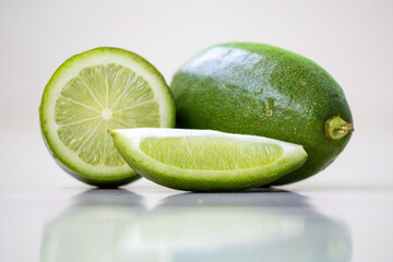 Fresh sliced green lemon (Citrus limon) and whole lemon isolated on a white background. In the Bengali language, it is called Lebu. 