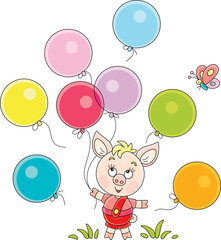 Obraz na płótnie Canvas Funny cartoony little piglet playing with colorful toy balloons and merry butterfly on a green summer lawn in a park, vector cartoon illustration on a white background