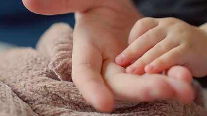 mother holds the hand of a newborn. children hand. hospital takes care of happy family medicine concept. newborn baby holding mom hand close-up. mom takes care baby in the hospital dream - 767823178