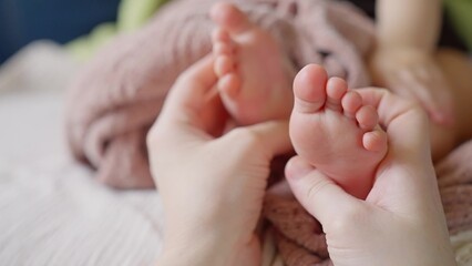 Mom doctor gives a foot massage to her baby. happy family kid baby concept. Children massage: care and care of the doctor mother. Foot massage baby health: doctor mom help. baby dream foot massage - 767823501