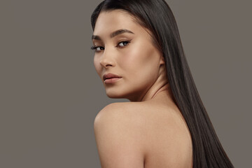 Luxurious young woman with naked back, long dark hair. - obrazy, fototapety, plakaty