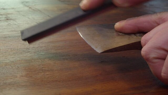 Old corroded axe gets a sharp new edge with a sharpening whetstone