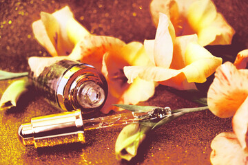 Close up of face beauty oil or serum in transparent dropper bottle,  flowers, golden glittering  ...