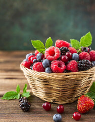 Basket full of berries on wooden table.