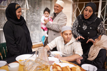 Muslim family, Eid and discussion by table with food for celebration, conversation and eating together. Islamic people, culture and religious holiday with lunch for nutrition, love and special event