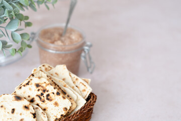 Handmade matzo in a wicker basket. Sweet condiment with apple-walnut charoset. Healthy food. Jewish Passover celebrations. 