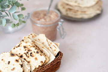 Handmade matzo in a wicker basket. Sweet condiment with apple-walnut charoset. Healthy food. Jewish Passover celebrations. 