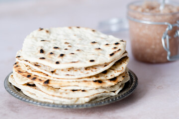Handmade round matzo in a plate. Sweet condiment with apple-walnut charoset on the table. Jewish Passover celebrations