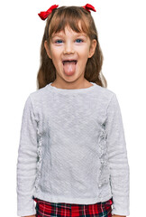 Little caucasian girl kid wearing casual clothes sticking tongue out happy with funny expression....