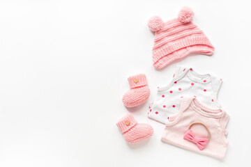 Set of baby girl dress - bodysuit with knitted hat and boots, top view. Kids clothing flat lay