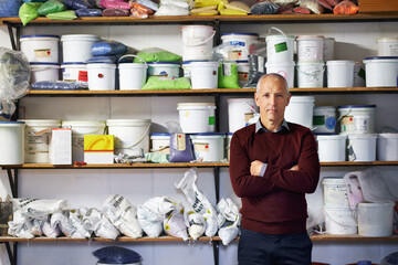 Man, merchandise and portrait in workshop or store for sale, retail or manufacturing for plastic goods for rendering service. Mature person or entrepreneur with confidence for stock and products