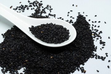 Black sesame seeds on a white spoon