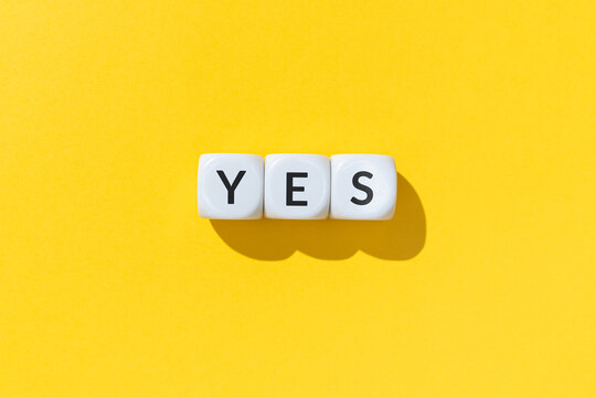 Yes word on white cube blocks isolated on yellow background
