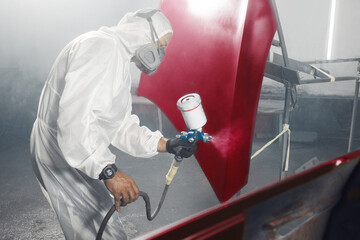 Finally painting a car body parts in paint and varnish chamber after work of vehicle body repair and restoration.