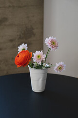 Small bouquet in a white ceramic cup in a sunny white interior