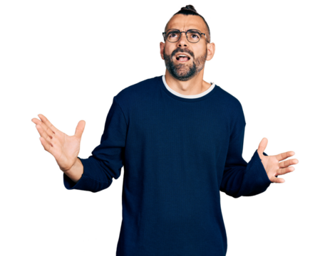 Hispanic man with ponytail wearing casual sweater and glasses crazy and mad shouting and yelling with aggressive expression and arms raised. frustration concept.