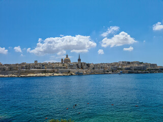 Fototapeta na wymiar Valletta, Malta - August 8th 2020: Blue sky and clouds above the fortified capital city overlooking Marsamxett Harbour.