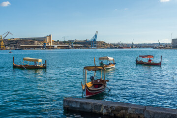 Valletta, Malta - September 14th 2022: Water taxis at the Lascaris Water Taxi station in the Grand Harbour waiting for customers. In the background is the Paola Dockyard.