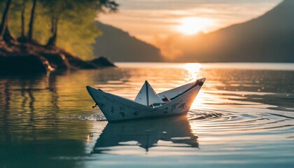 Paper boat in cal peaceful water at sunset creating sense of relexing peaceful for meditation  - obrazy, fototapety, plakaty