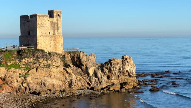 Torre de la Sal in Casares Manilva beach in Spain, coastal tower system for surveillance and defence against Berber pirates, green plants at the sunny beach, 4K static shot