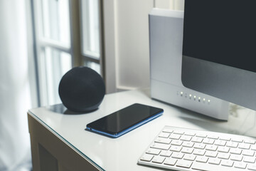 Smartphone, wifi speaker, router and computer on desk. Technology, domotics, home automation concept
