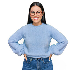 Young hispanic woman wearing casual clothes and glasses with a happy and cool smile on face. lucky...
