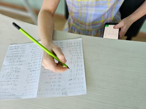 Student is cheating at the test exam with cheat answer written on smartphone concept