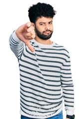 Young arab man with beard wearing casual striped sweater looking unhappy and angry showing rejection and negative with thumbs down gesture. bad expression.