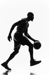 Fototapeta na wymiar Silhouette of male, skilled basketball player dribbling, captured in high-contrast black and white filter.