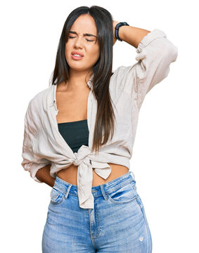 Young beautiful hispanic girl wearing casual clothes suffering of neck ache injury, touching neck with hand, muscular pain