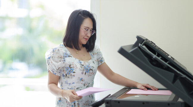 Asian beautiful women using photocopier for photocopy documents. Soft and selective focus.
