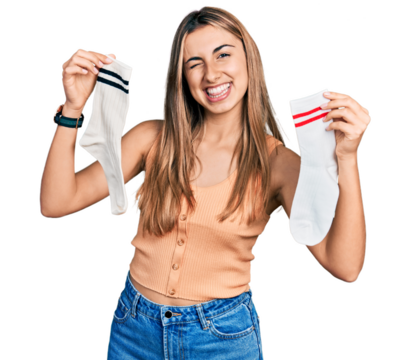Hispanic young woman holding socks winking looking at the camera with sexy expression, cheerful and happy face.
